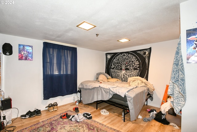 bedroom with wood-type flooring and a textured ceiling