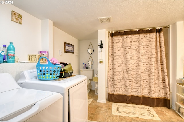 clothes washing area featuring washing machine and dryer and a textured ceiling