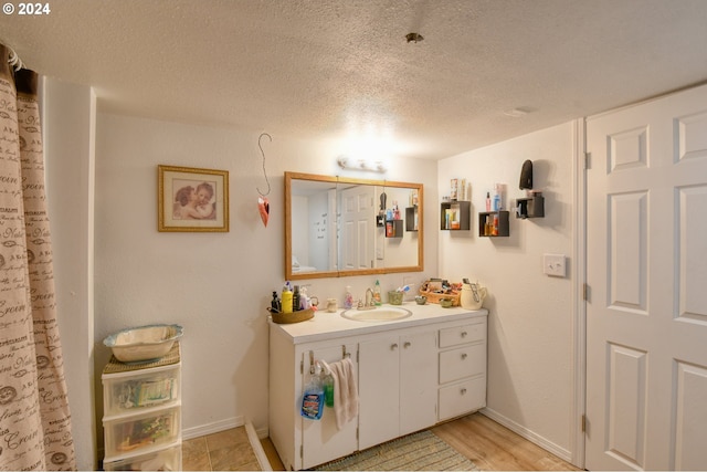 bathroom featuring hardwood / wood-style floors, vanity, and a textured ceiling