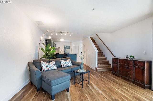 interior space with light hardwood / wood-style floors and rail lighting