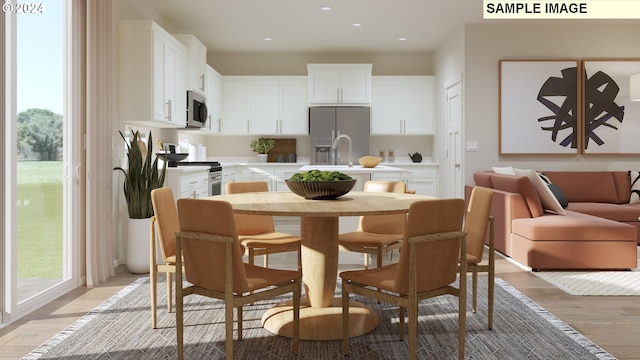 kitchen featuring appliances with stainless steel finishes, light wood-type flooring, and white cabinetry