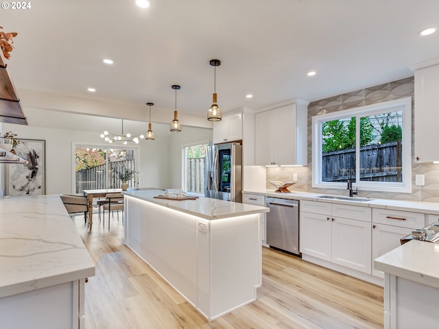 kitchen featuring stainless steel appliances, decorative backsplash, and white cabinets