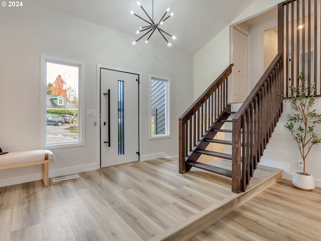 foyer featuring light wood-type flooring and a chandelier