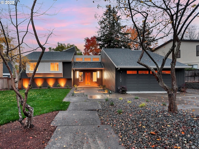 view of front of home with a garage and a lawn