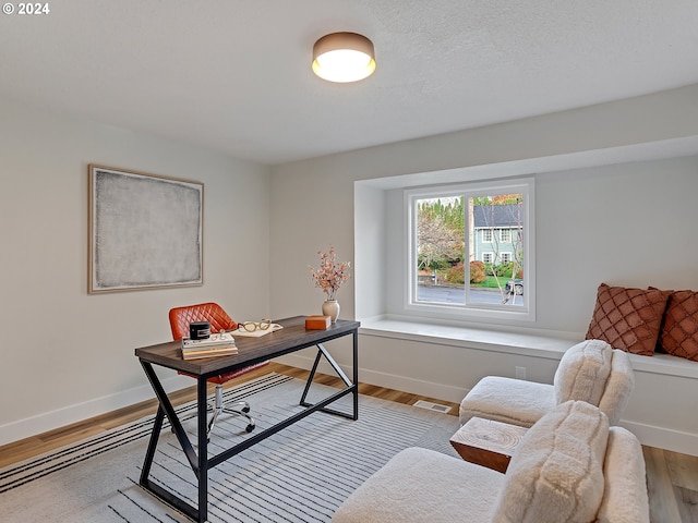 home office with light hardwood / wood-style floors