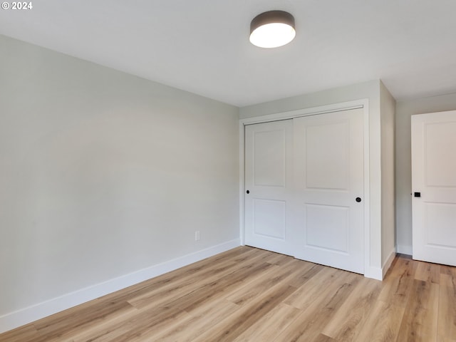 unfurnished bedroom with a closet and light hardwood / wood-style flooring