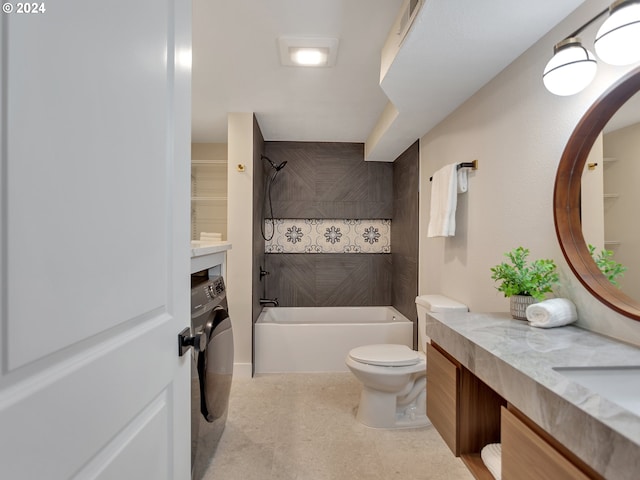 full bathroom featuring tub / shower combination, toilet, vanity, and washer / clothes dryer