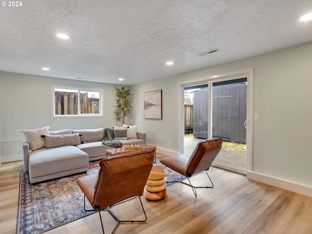 living room featuring a textured ceiling and light hardwood / wood-style floors