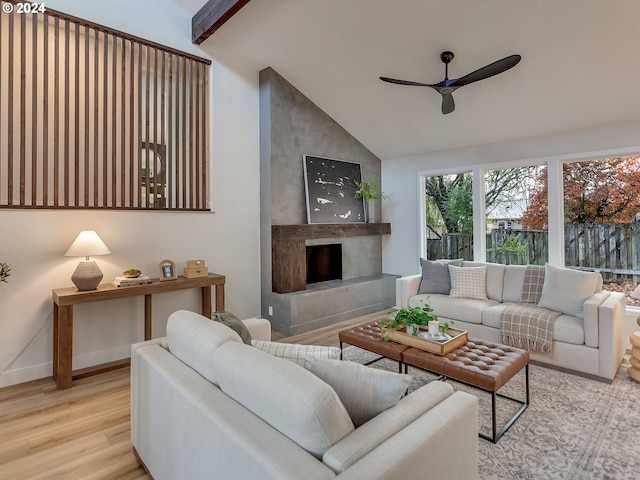 living room featuring ceiling fan, light hardwood / wood-style floors, and vaulted ceiling