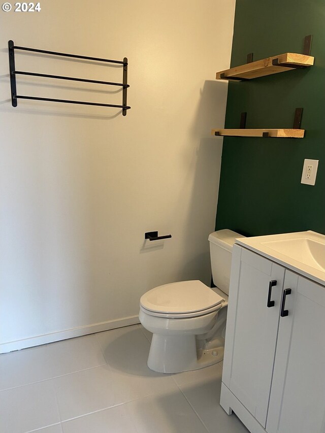 bathroom with tile patterned flooring, vanity, and toilet