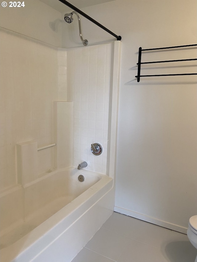 bathroom featuring toilet, tile patterned flooring, and tiled shower / bath