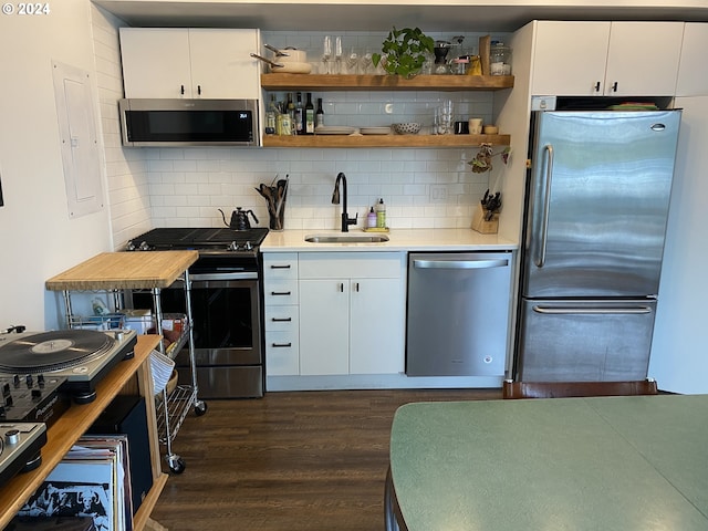 kitchen featuring white cabinets, appliances with stainless steel finishes, dark wood-type flooring, and sink