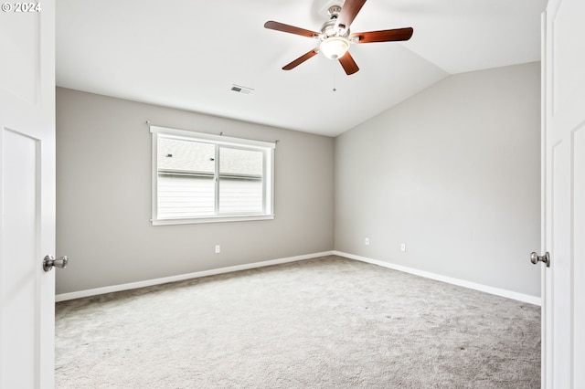 spare room featuring light carpet, ceiling fan, and vaulted ceiling