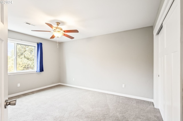 unfurnished bedroom featuring carpet floors, a closet, and ceiling fan