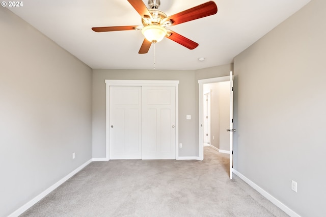 unfurnished bedroom with light carpet, a closet, and ceiling fan