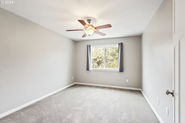 carpeted spare room with ceiling fan