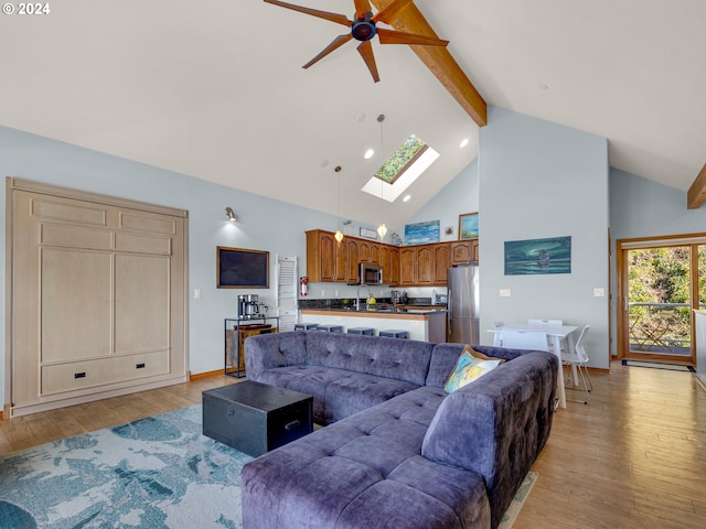 living room featuring high vaulted ceiling, light wood-type flooring, ceiling fan, and beam ceiling