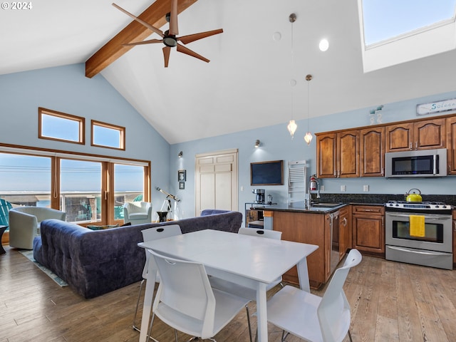 kitchen with stainless steel appliances, high vaulted ceiling, pendant lighting, beamed ceiling, and light hardwood / wood-style flooring