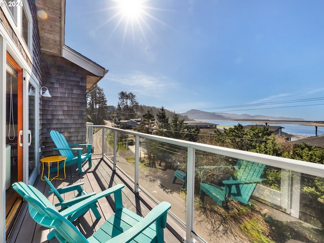 balcony featuring a water and mountain view