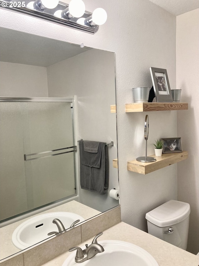 bathroom with vanity, an enclosed shower, and toilet