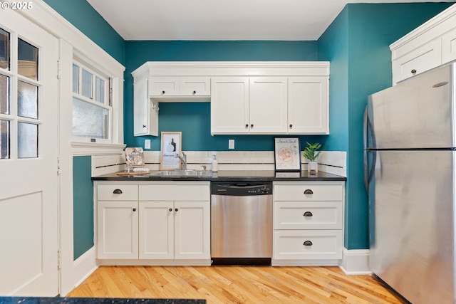 118 NW King Ave Unit 52, Portland, OR 97210 - kitchen featuring gas stove, ornamental molding, white cabinets, and dark countertops