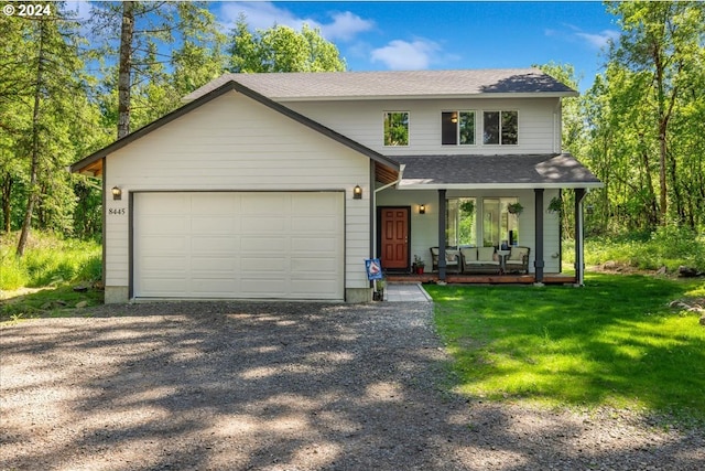 front facade featuring a front yard, a porch, and a garage