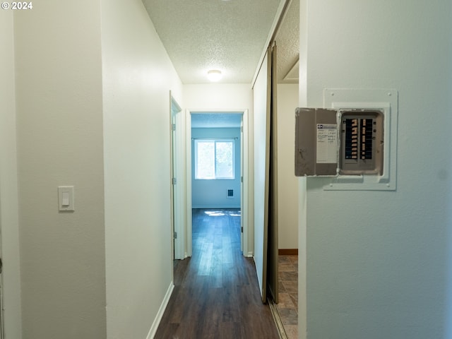 hallway with dark hardwood / wood-style flooring and a textured ceiling