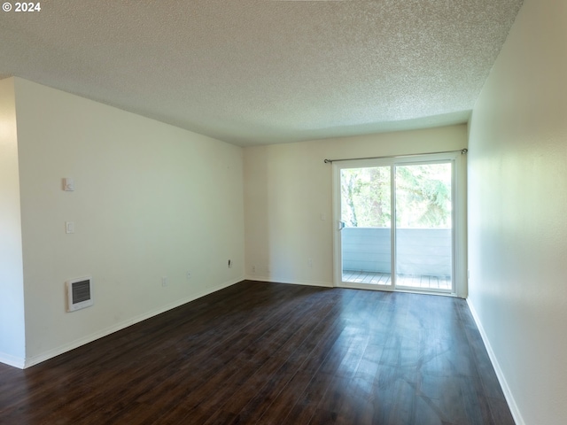 spare room with dark hardwood / wood-style flooring and a textured ceiling