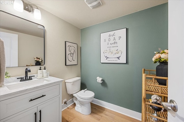 bathroom with vanity, toilet, and hardwood / wood-style floors