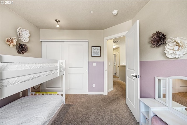 bedroom featuring carpet flooring, a textured ceiling, and a closet