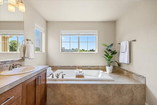 bathroom featuring a relaxing tiled tub, vanity, and decorative backsplash