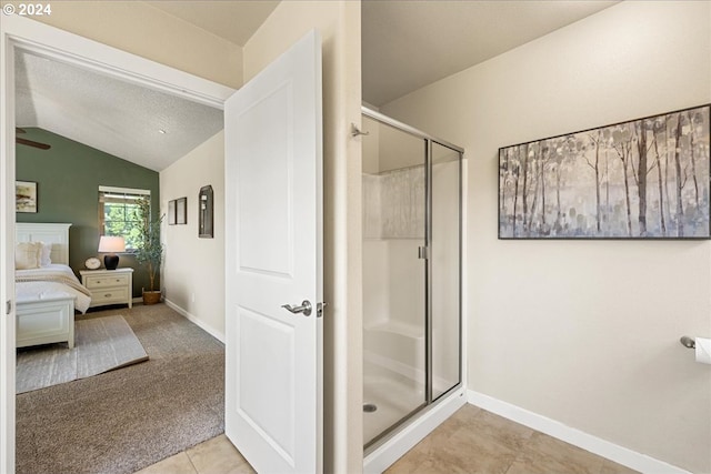 bathroom featuring tile patterned floors, lofted ceiling, and a shower with door