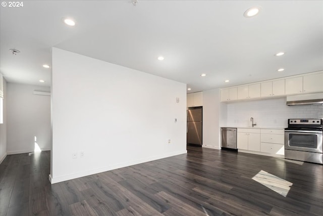 kitchen with tasteful backsplash, stainless steel appliances, white cabinetry, dark hardwood / wood-style flooring, and sink