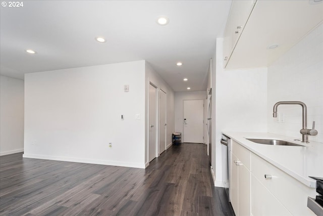 kitchen with white cabinetry, sink, stainless steel dishwasher, and dark hardwood / wood-style floors