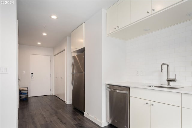 kitchen featuring stainless steel appliances, white cabinetry, decorative backsplash, sink, and dark wood-type flooring