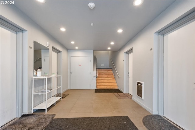 hallway featuring heating unit and light tile patterned floors