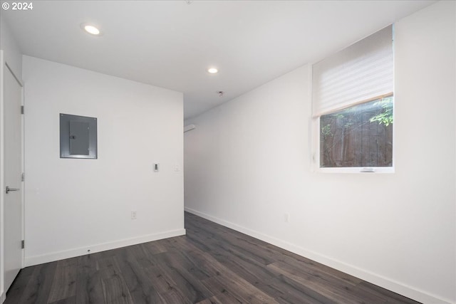 unfurnished room with electric panel and dark hardwood / wood-style flooring