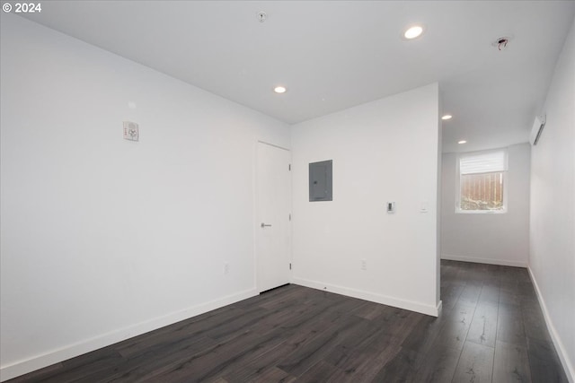 spare room with electric panel and dark hardwood / wood-style floors