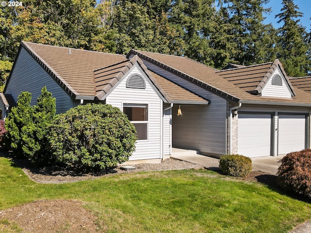 ranch-style home featuring a front lawn and a garage