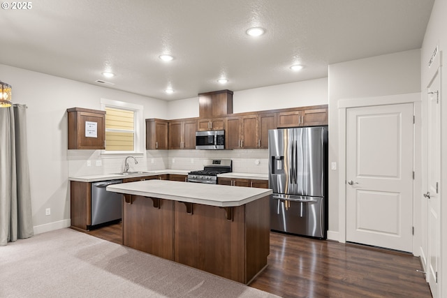 kitchen featuring stainless steel appliances, a kitchen breakfast bar, a kitchen island, and backsplash