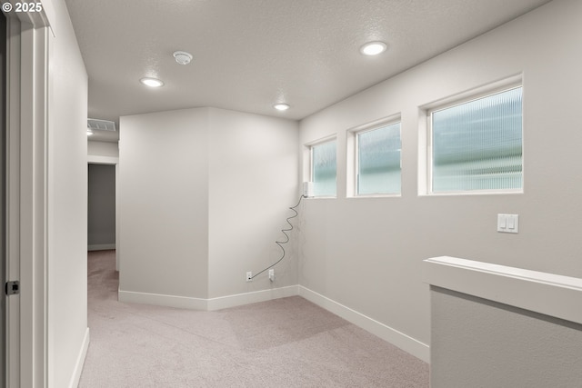 carpeted empty room featuring a textured ceiling