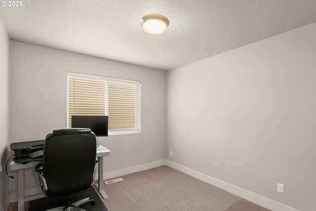 carpeted office space with a textured ceiling