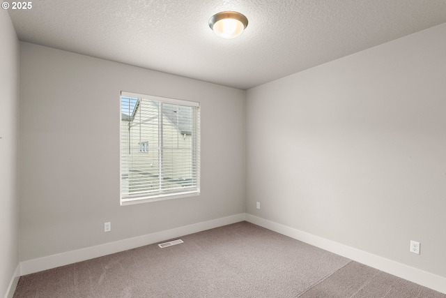 unfurnished room featuring a textured ceiling and carpet