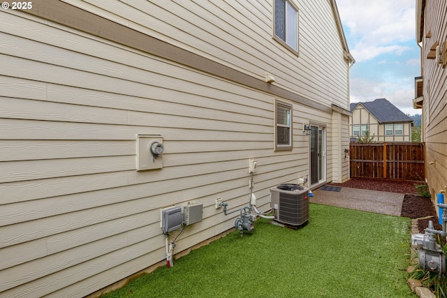 view of property exterior with cooling unit, a yard, and a patio area