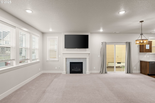 unfurnished living room with light colored carpet, a textured ceiling, and a fireplace