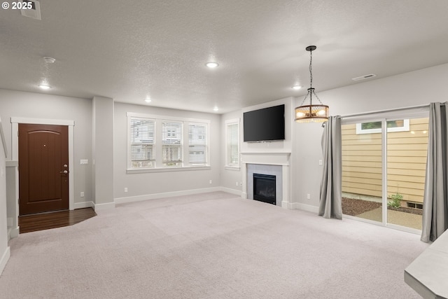 unfurnished living room with carpet floors and a textured ceiling