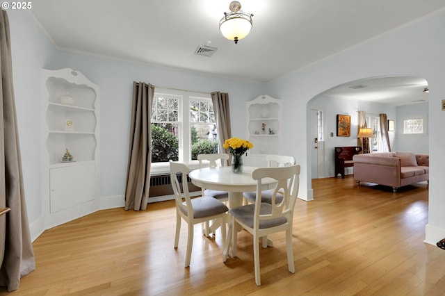 dining area featuring built in shelves and light wood-type flooring