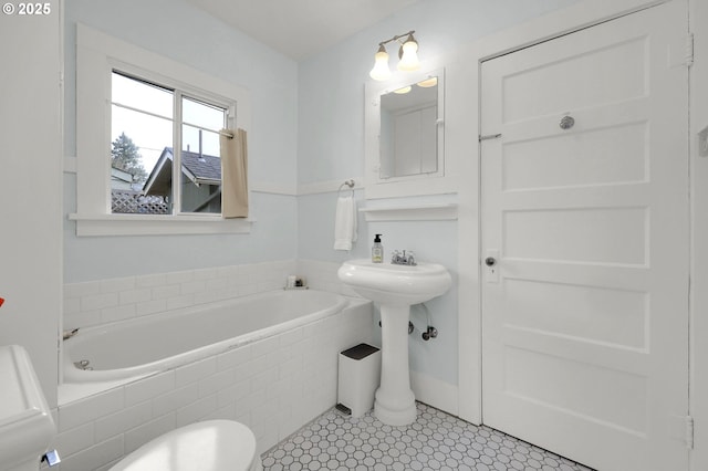 bathroom with tile patterned flooring and tiled bath