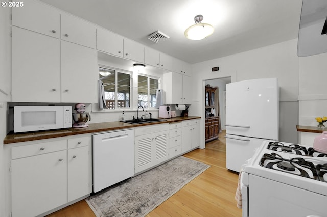 kitchen featuring white cabinets, light hardwood / wood-style floors, white appliances, and sink