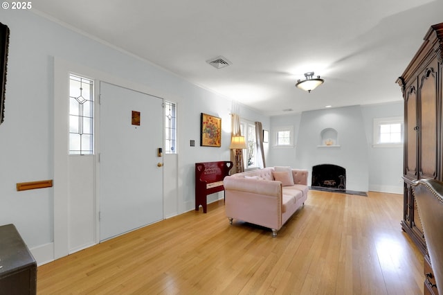 living room with ornamental molding and light wood-type flooring